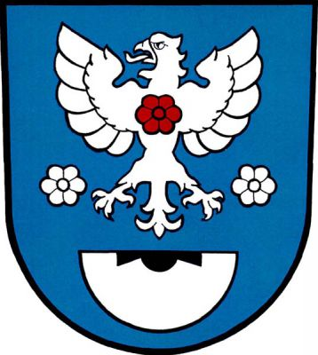 V modrém štítě nad dolní polovinou stříbrného mlýnského kamene s černou kypřicí stříbrná orlice s červeným květem na hrudi, dole provázená dvěma stříbrnými květy. Znak Rusín